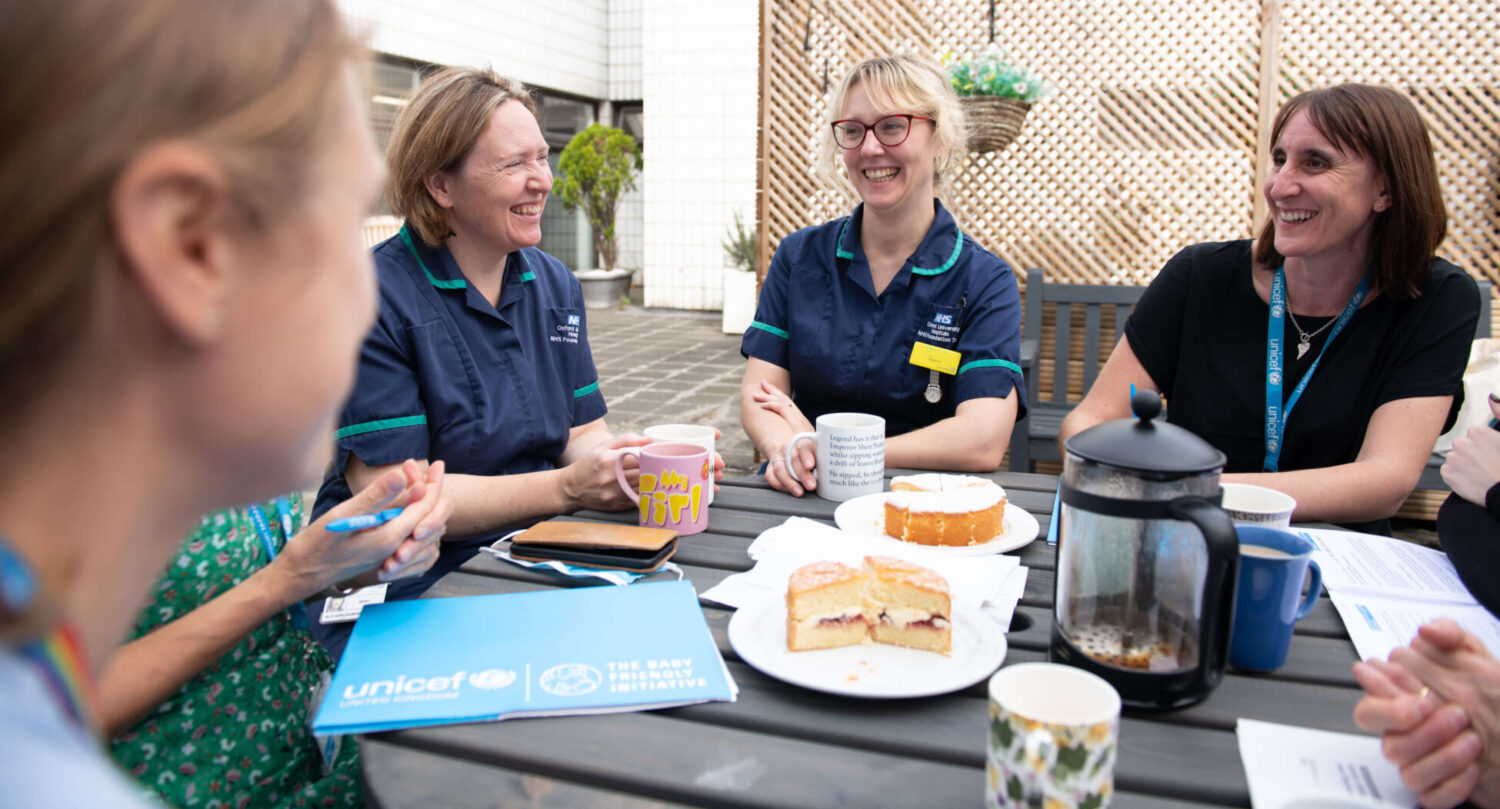 A team of infant feeding healthcare professionals gather around a table for a meeting