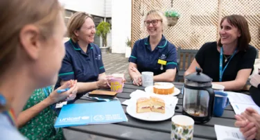 A team of infant feeding healthcare professionals gather around a table for a meeting