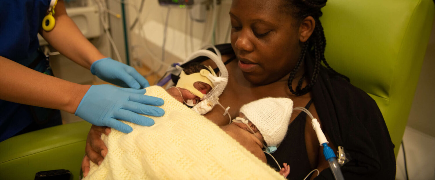 A mother of twins holds her babies in skin-to-skin contact on the neonatal unit.