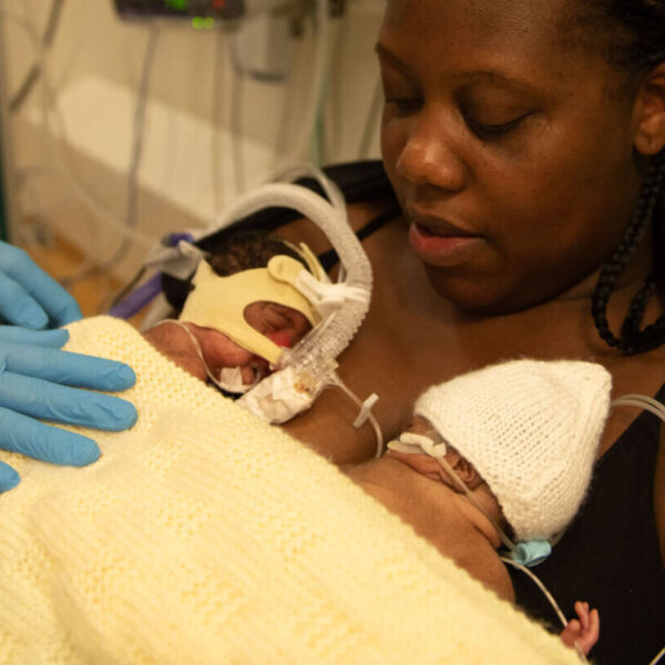 A mother of twins holds her babies in skin-to-skin contact on the neonatal unit.