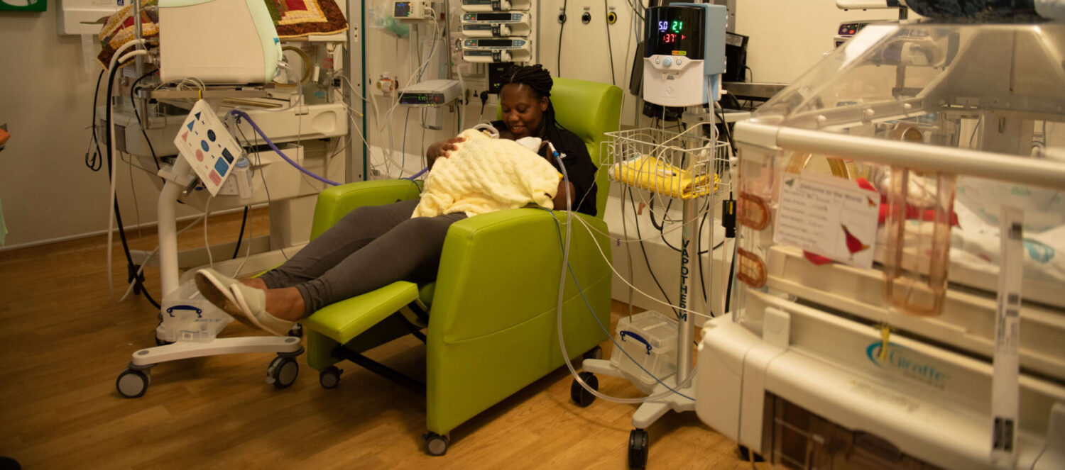 A mother of twins holds her babies in skin-to-skin contact on the neonatal unit.