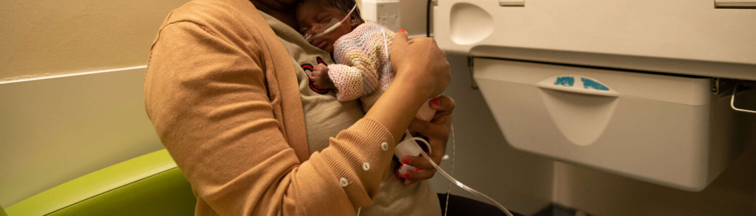 A mother holds her newborn infant on the neonatal unit.