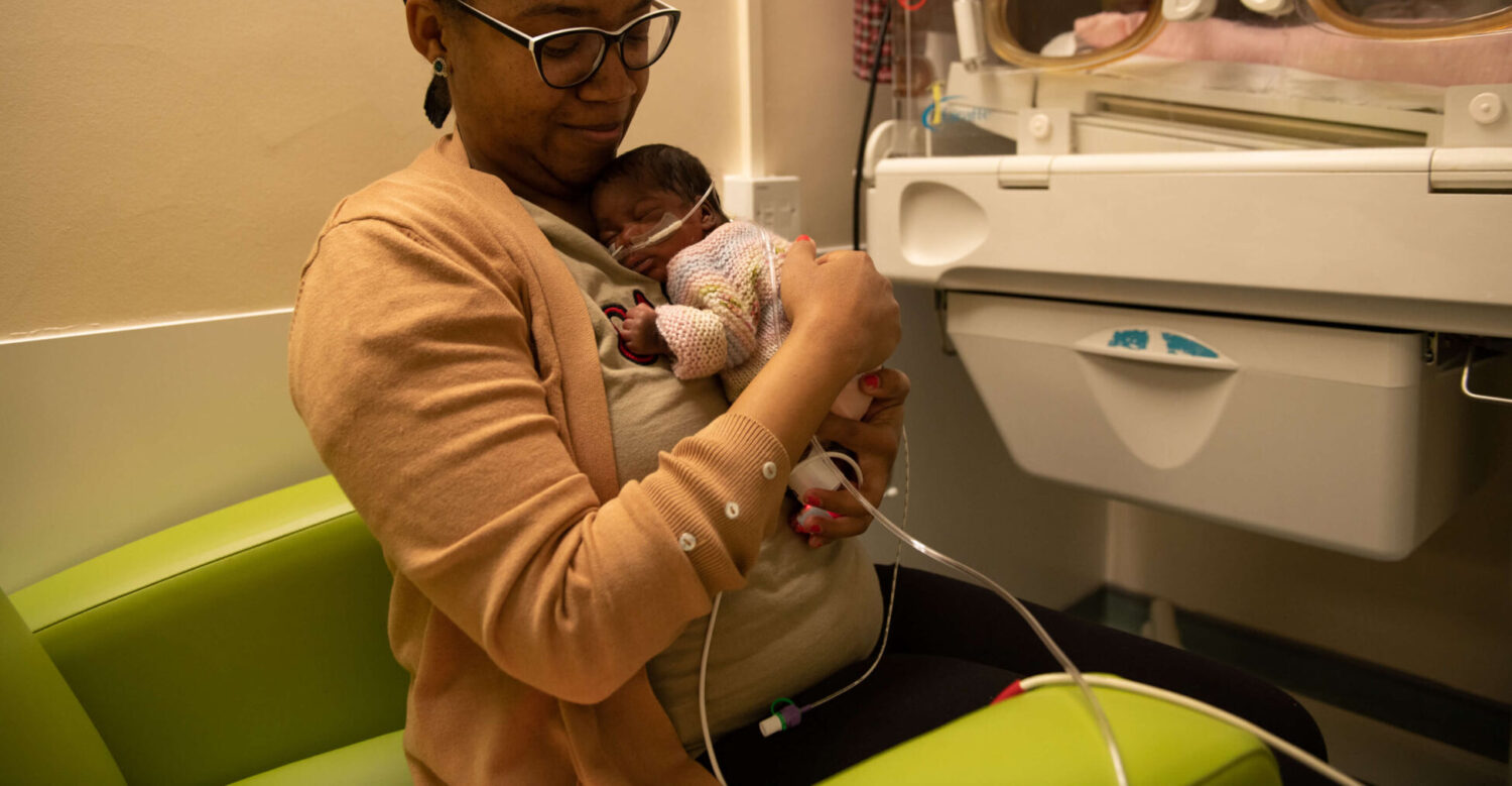 A mother holds her newborn infant on the neonatal unit.