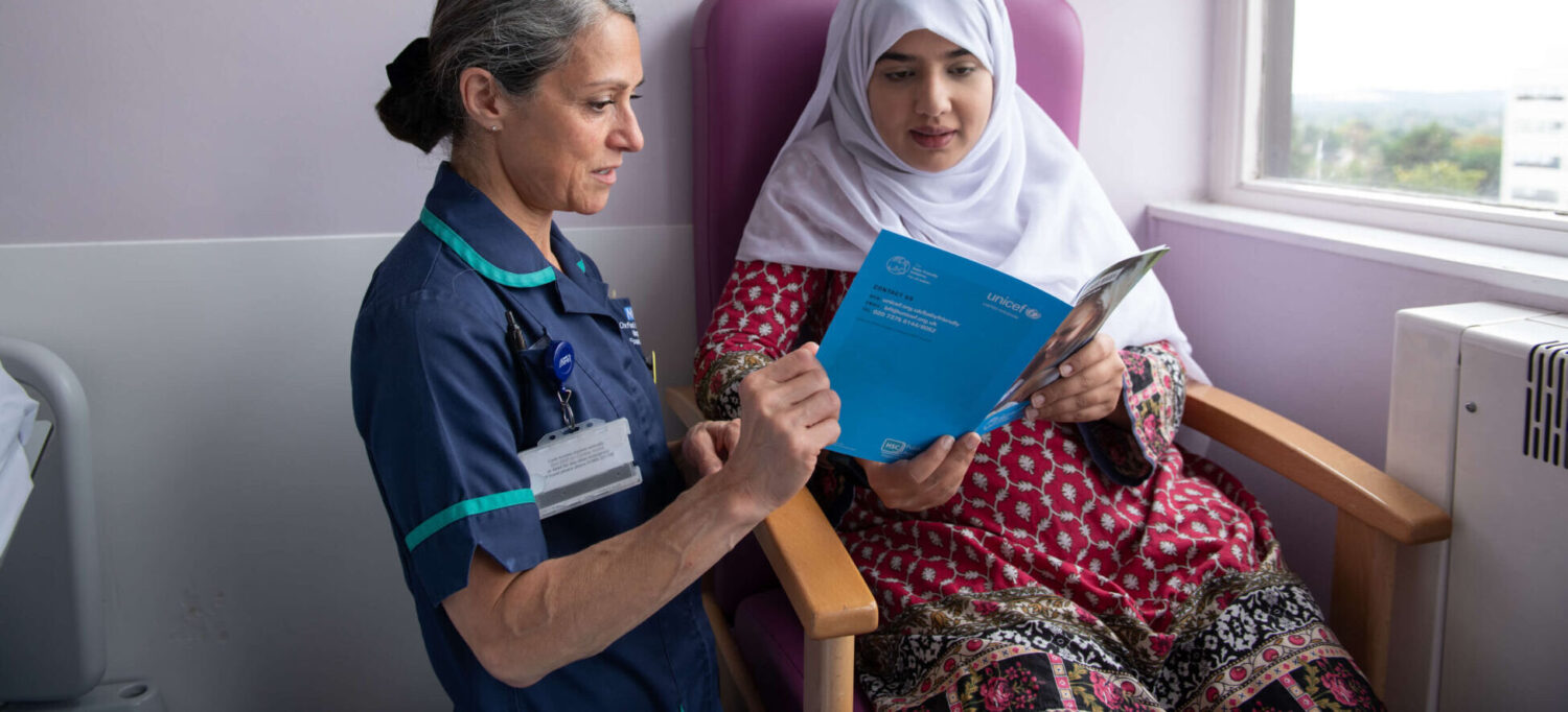 An infant feeding healthcare professional supports a pregnant woman with guidance produced by the UNICEF UK Baby Friendly Initiative