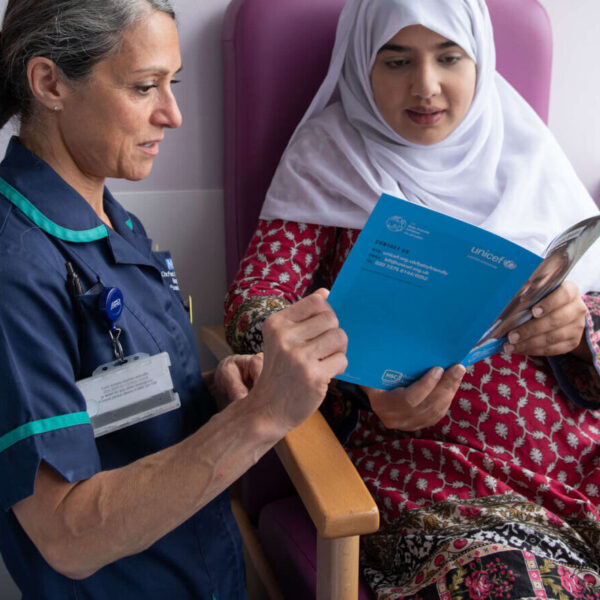 An infant feeding healthcare professional supports a pregnant woman with guidance produced by the UNICEF UK Baby Friendly Initiative