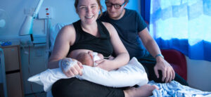 Smiling mum breastfeeding with partner