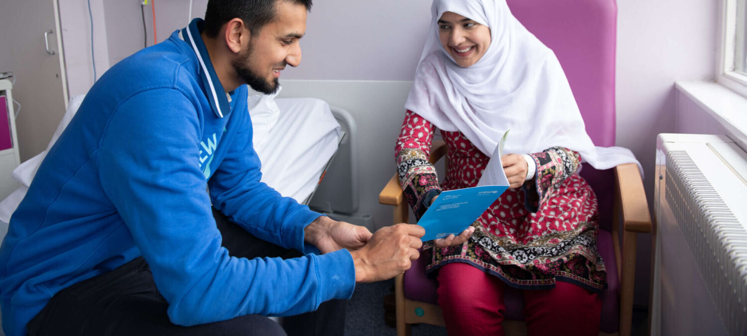 Expecting mother and father read a Baby Friendly leaflet on caring for baby