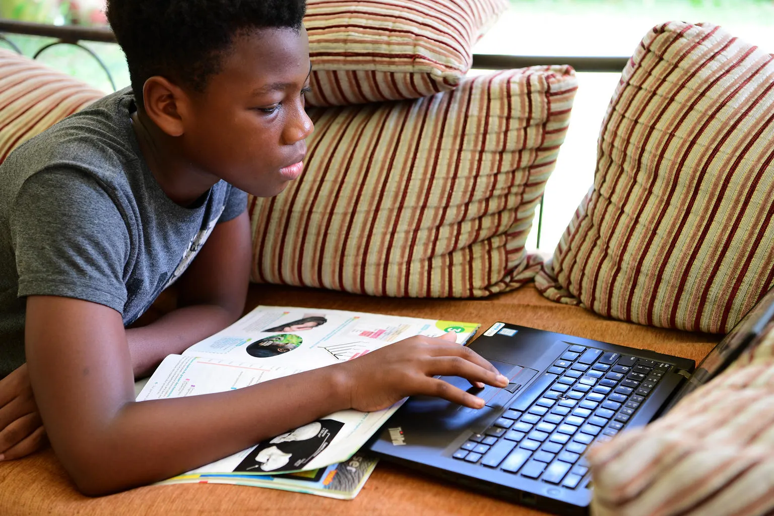 A boy is studying at home, in Abidjan, in the South of Côte d'Ivoire.