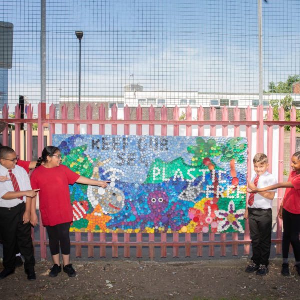 A group of pupils pointing at their 'Keep our sea plastic free' display