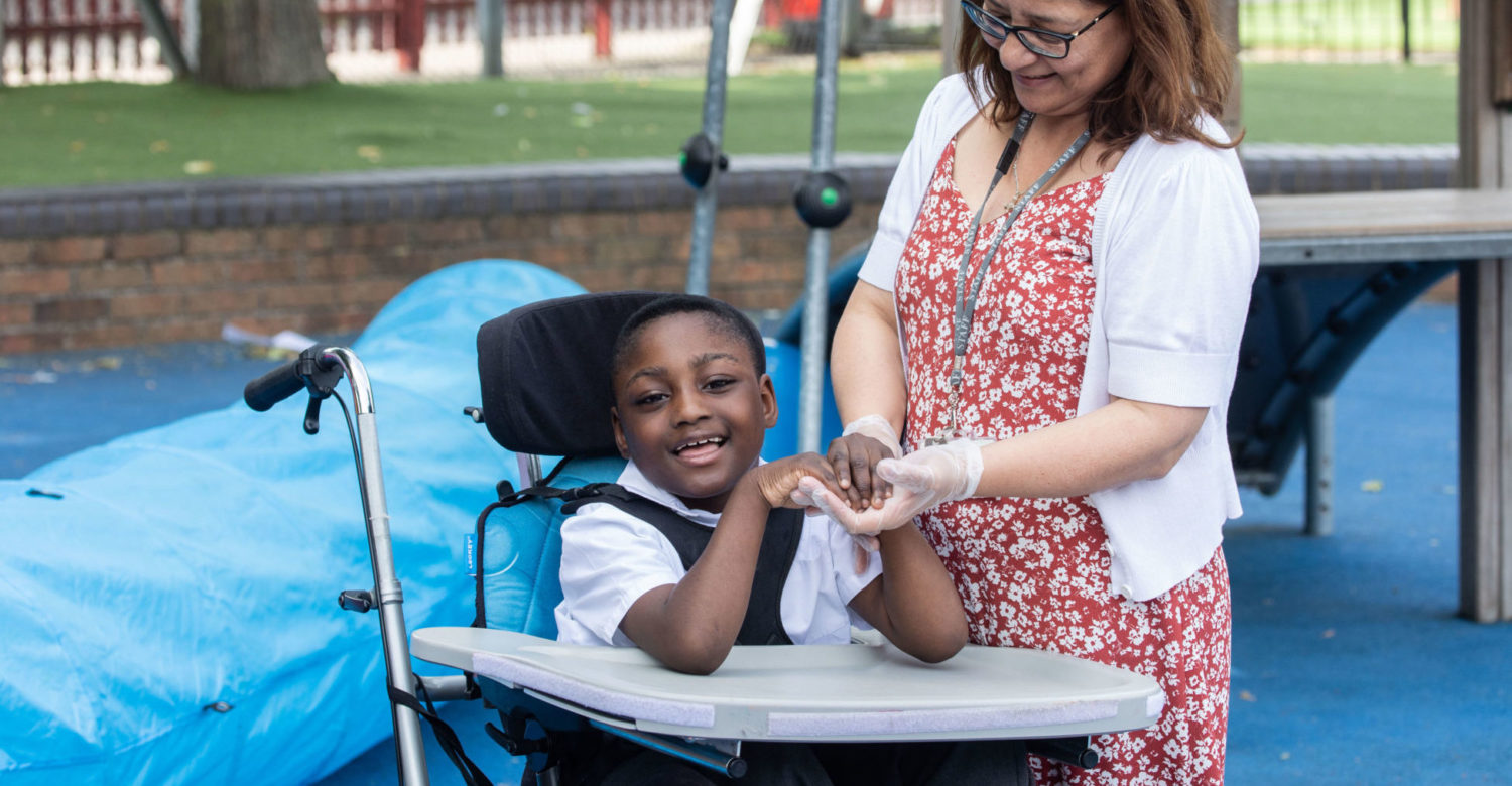 Teacher supporting a pupil in a wheelchair