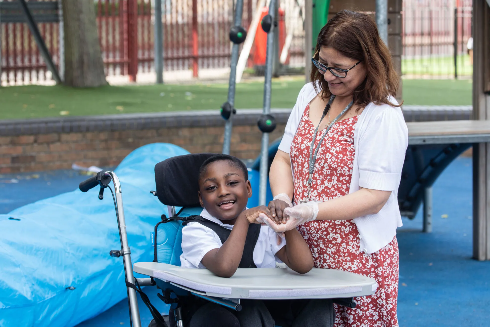 Teacher supporting pupil in a wheelchair