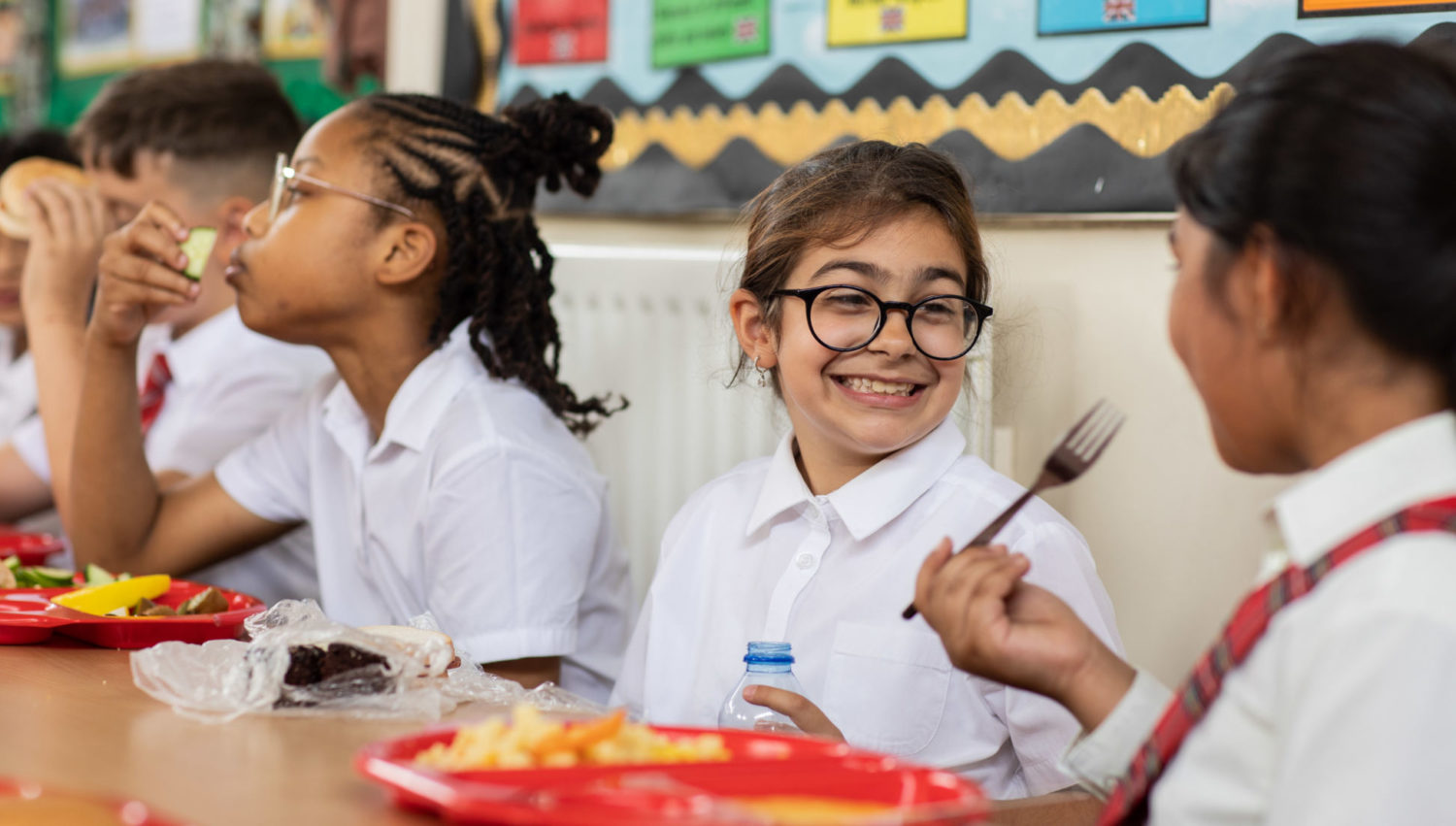 Pupils interacting and smiling whilst having lunch