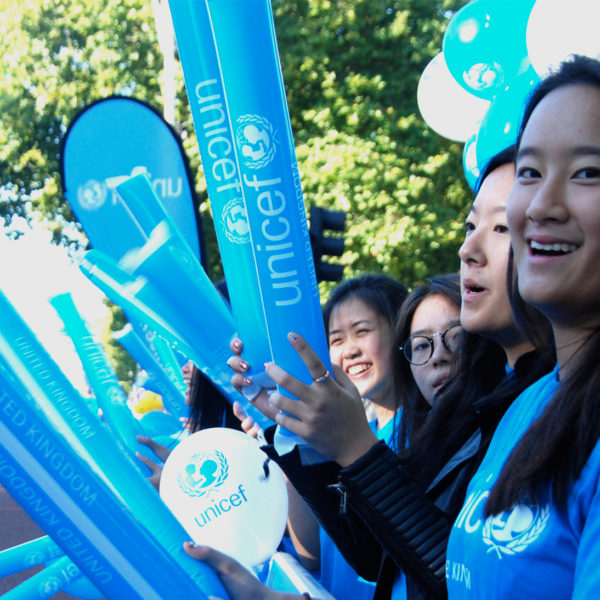 Volunteer cheering on Team UNICEF runners at a challenge event.