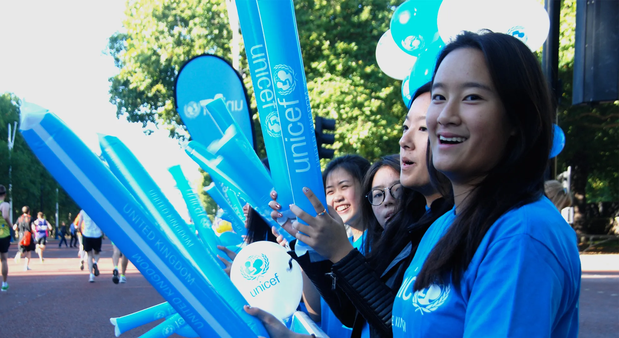 Volunteer cheering on Team UNICEF runners at a challenge event.