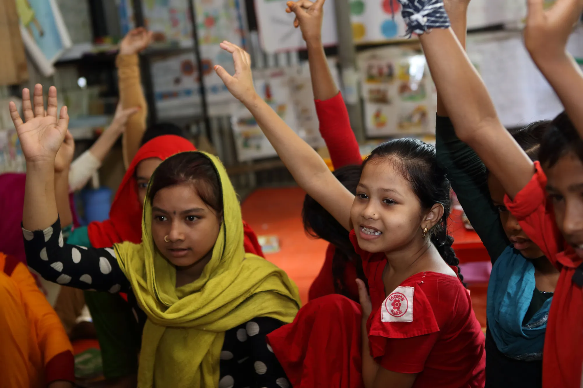 Children raise their hands at a Unicef-supported school in Bangladesh. Photo: Unicef 2016 Kiron
