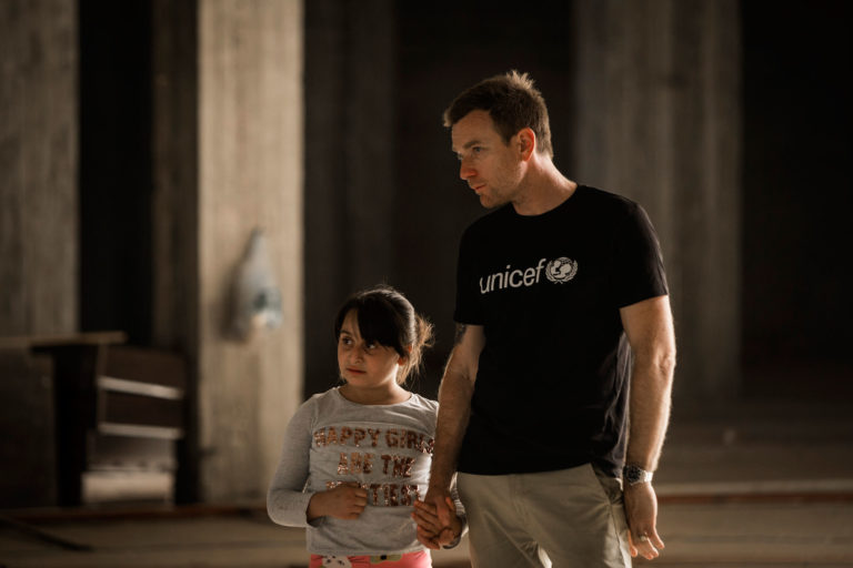 Ewan and Mirna walk through the disused shopping mall where she and her family slept for over a year. Unicef/2016/Modola