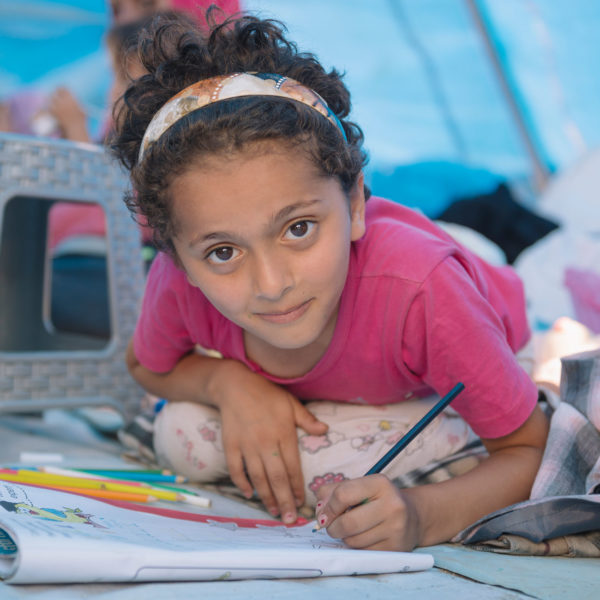 Girl drawing in a child-friendly space in Syria