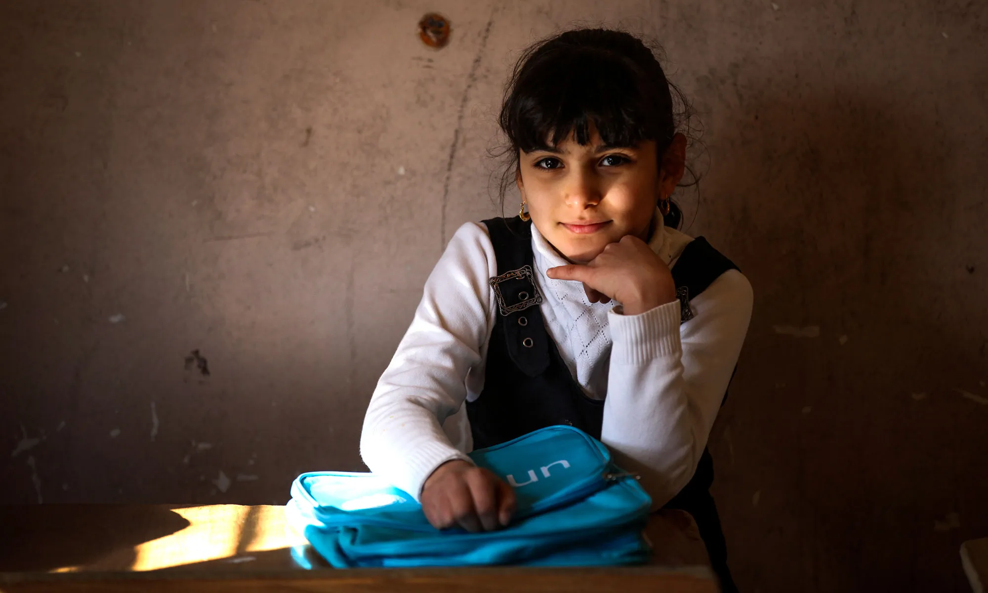 Janna, 8, from Baghdad, sits in a classroom with her new Unicef school bag after a school supply distribution for children from five schools in Baghdad's Al-Amiriyah District.
