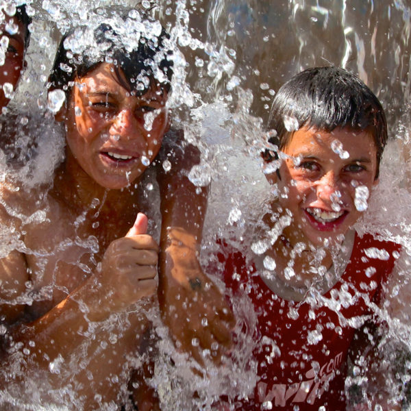 Group of children splashing in water in Dohuk Governorate.