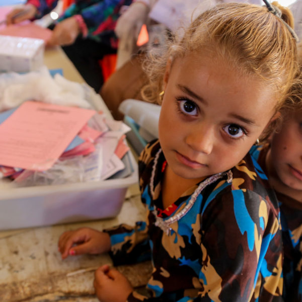 Two girls wait in line at a temporary medical centre in Iraq.