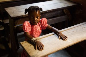 A girl sits at her desk at school in Guinea. Her school has just reopened after the Ebola crisis and Unicef is supporting teachers to implement safety measures against the disease. Photo: Unicef/Guinea 2015/Perret