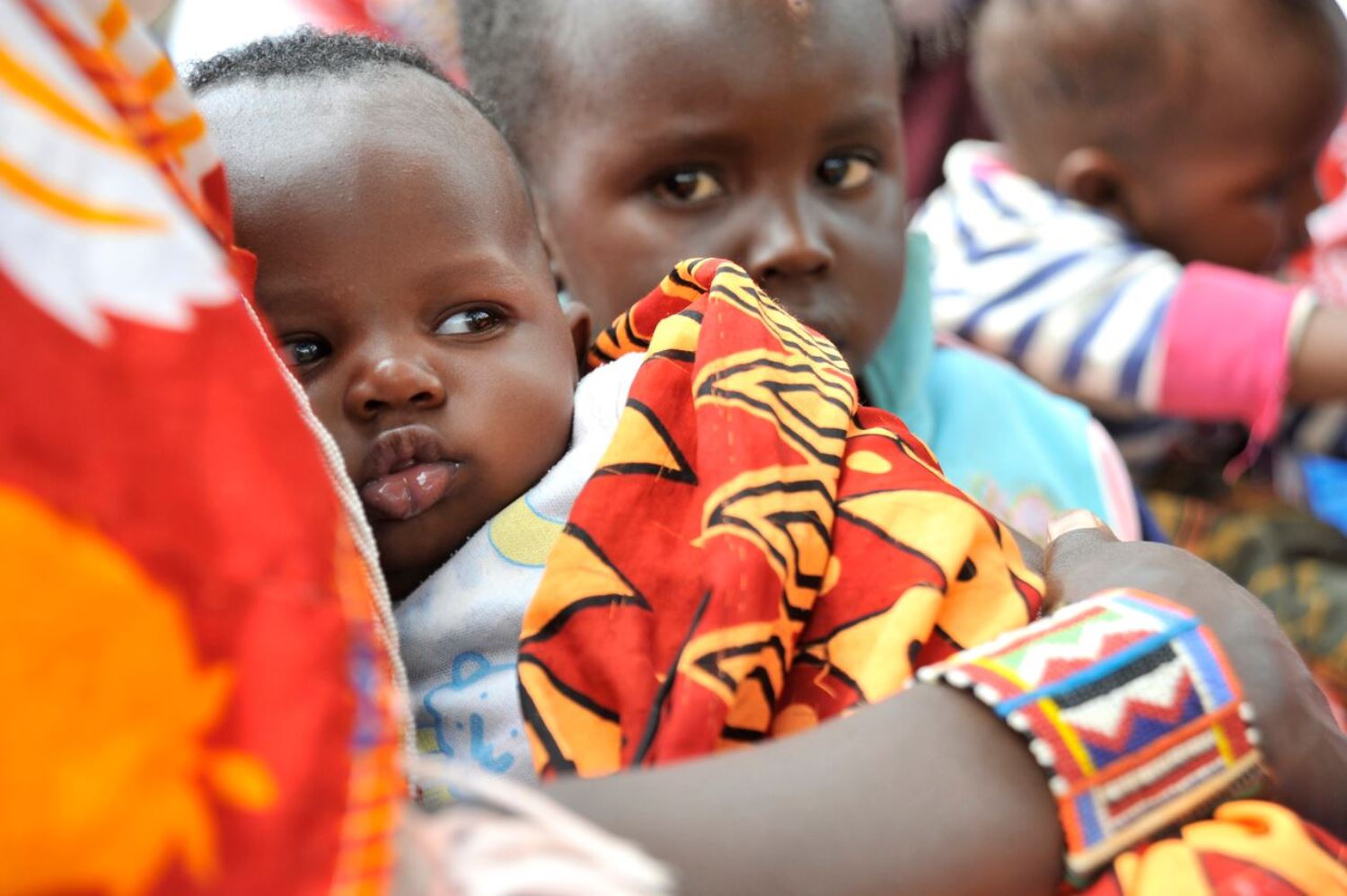 A baby with her mum who is waiting to receive a maternal and newborn tetanus vaccination at a health centre in Kenya © UNICEF UK 2015