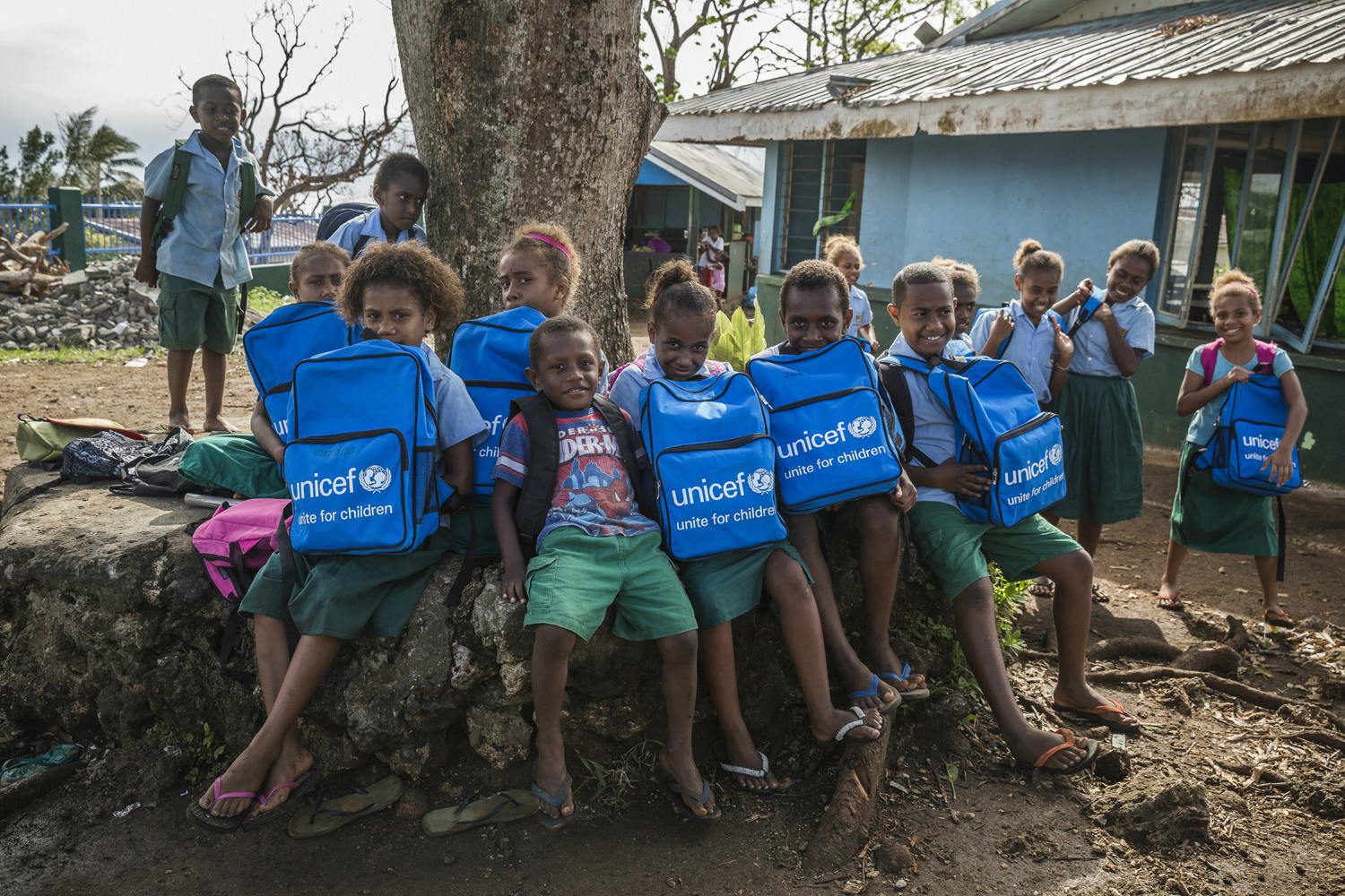 Children proudly hold their new school bags. After a disturbing event like Cyclone Pam it's important to get children back to learning and playing as soon as possible.