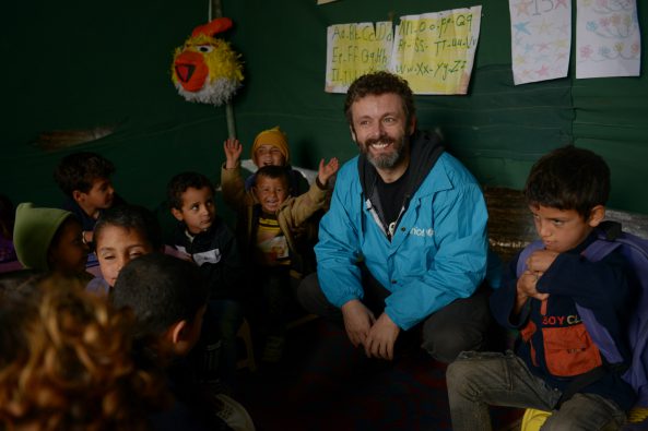 Michael Sheen meets Syrian refugee children in Lebanon as they receive their first winter supplies from Unicef - including boots, gloves and warm clothing. Photo: Unicef/2013/Brooks