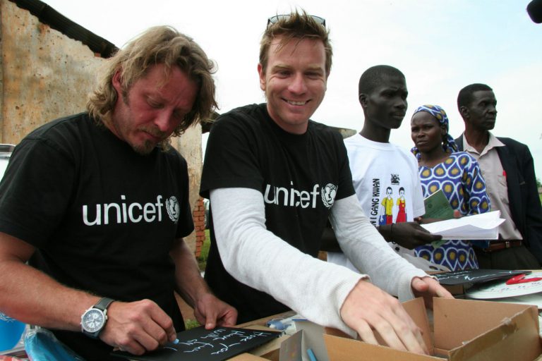 Ewan McGregor and Charlie Boorman at a Unicef project in Uganda. You can help build a better world for children by leaving a gift in your Will.