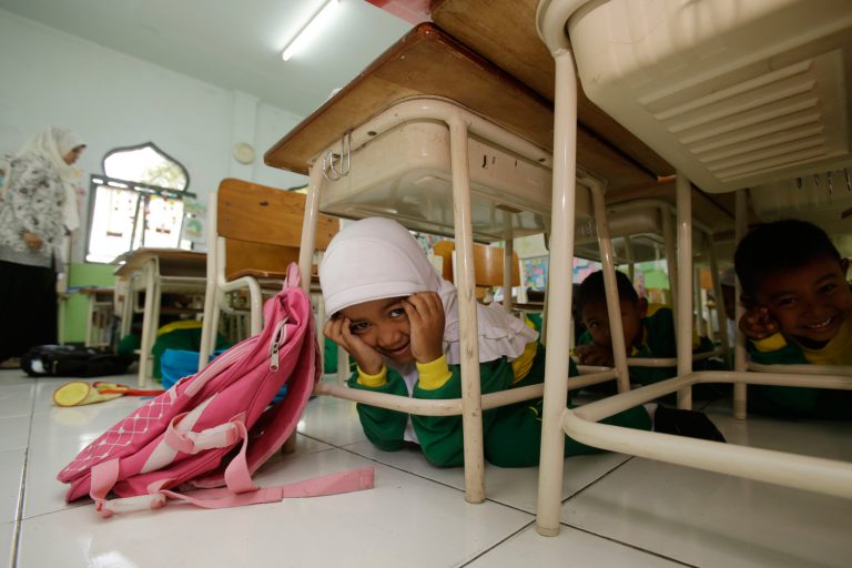 Students sit under a table during an earthquake drill at a primary school in Indonesia, which was struck by the deadly Boxing Day Tsunami in 2004. Photo: Unicef/2014/Achmadi