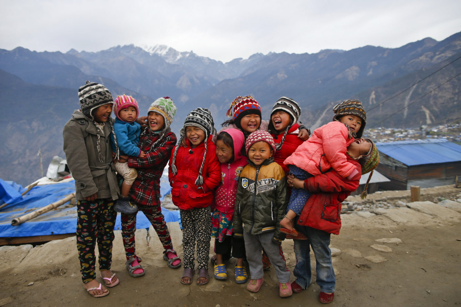 On 18 January 2016, children laugh in Barpak village, Gorkha district, Nepal. Barpak is an epicenteral village of Gorkha district, where more than 1400 hundreds houses were destroyed during the earthquake on 25 April 2015. Hundreds of earthquake victims, particularly the elderly and young children living in shelter of highland altitude have been facing a harsh winter season after snowfall.