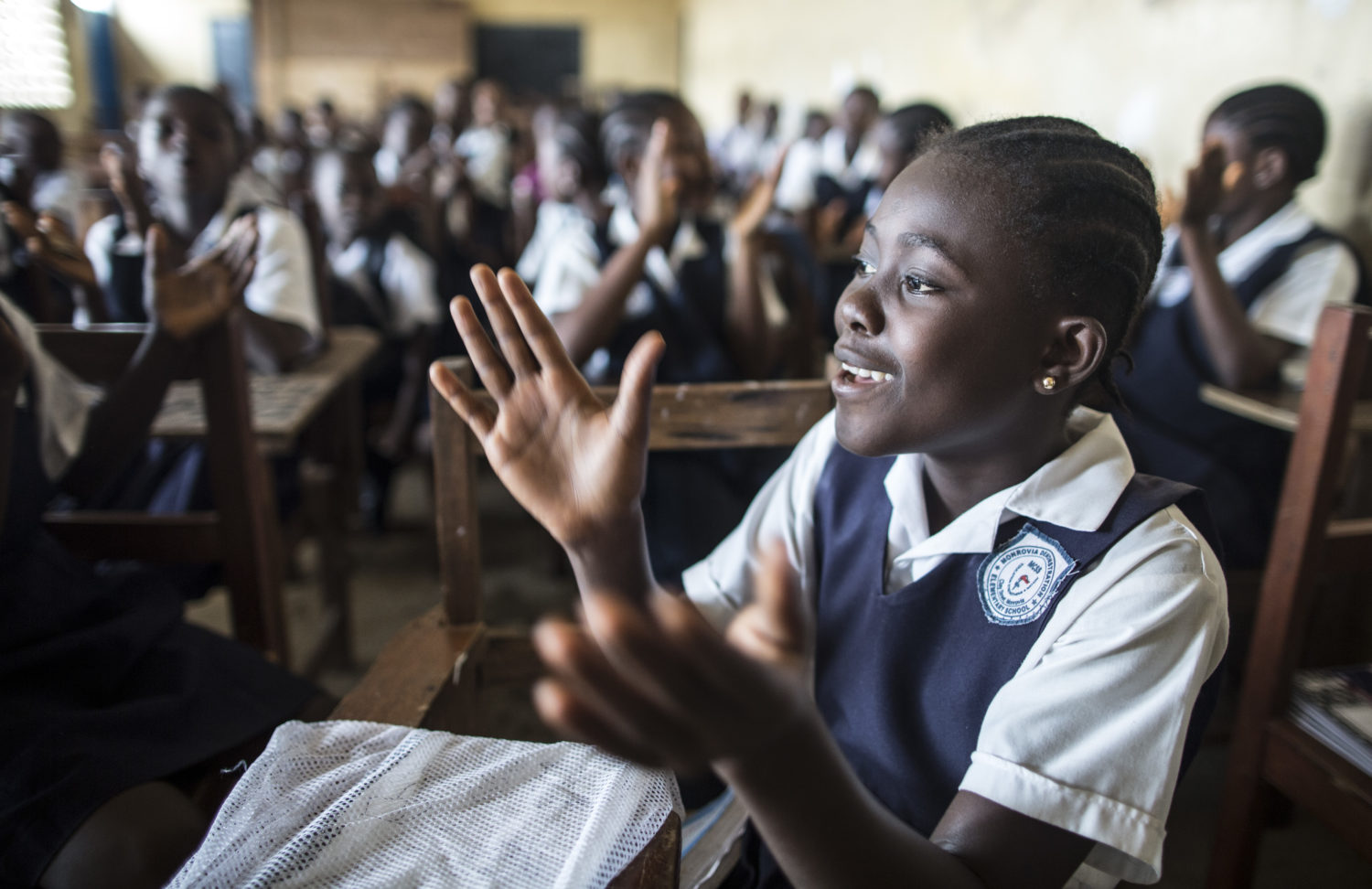 A girl claps during a sing-along in a class at Monrovia Demonstration School in Monrovia, the capital, on the first day of the new academic year.