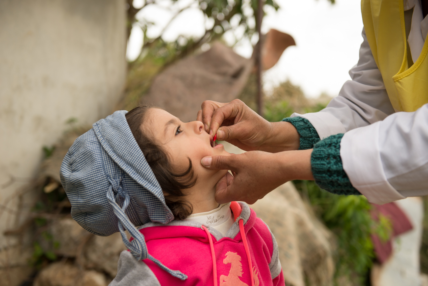 A young girl receives a vaccination from a health worker