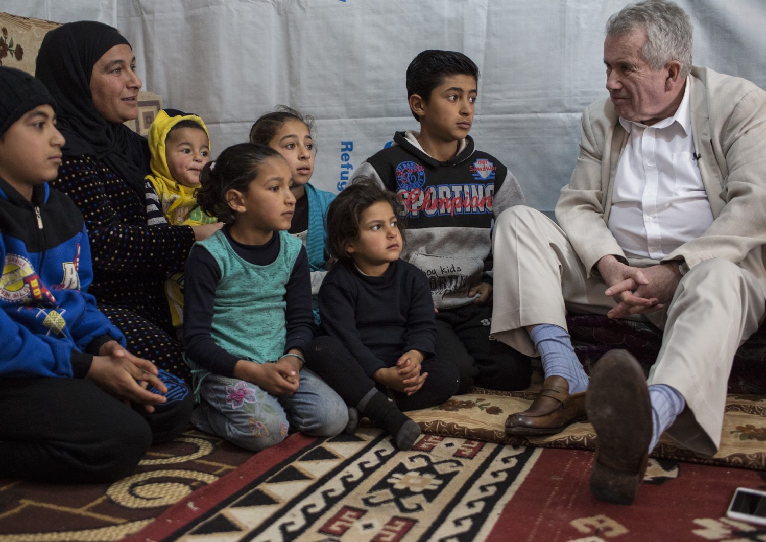 Martin Bell, UNICEF UK Ambassador and veteran BBC reporter (right), meets with Nisrine, 31 (2nd from left) who fled Raqqa six months ago. He talks about the change you make through a Unicef Gift in Your Will.