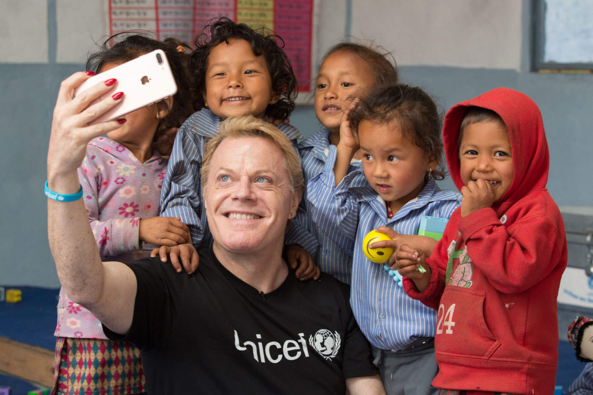 Unicef UK Ambassador Eddie Izzard visits Sree Shankheswori Primary School in Kabhrepalanchowk, Nepal. Following the devastating earthquakes of 2015, Shankheswori is one of 650 schools in the region that Unicef has helped by rebuilding damaged classrooms to ensure that children don’t miss out on their education. Unicef has also provided back-to-school kits with recreational and educational supplies, trained teachers to provide psycho-social support to traumatised pupils and taught them how to stay safe in the event of another earthquake. Kavrepalanchowk District, Nepal. 19th February 2017 © UNICEF/ Matas