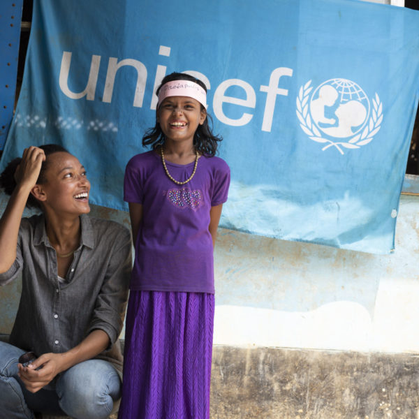 On 4 April 2018 in Bangladesh, (left) German model Nur Hellmann laughs with a Rohingya girl at an awards ceremony taking place outdoors, during her visit to a UNICEF-supported learning centre in the Kutupalong makeshift settlement for Rohingya refugees, in Cox’s Bazar district. Almost 750,000 Rohingya have fled Myanmar and sought refuge in neighbouring Bangladesh since violence erupted in their homeland on 25 August 2017. More than half of them are children. UNICEF and partners are working to meet the needs of this enormous refugee population, which will be even more vulnerable during the upcoming rainy season photo by Brian Sokol