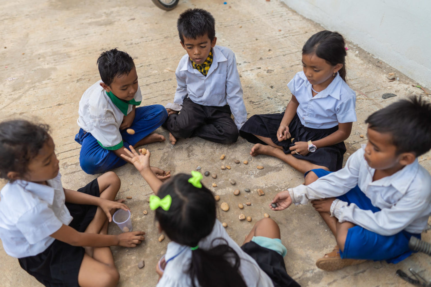 Children sit together in a circle playing together,