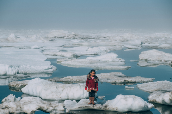 A young girl stands on an ice floe
