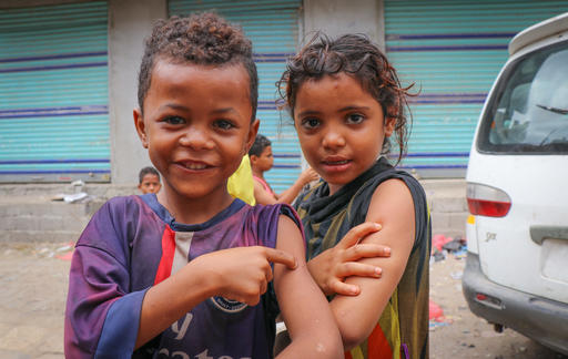 children in Yemen show off their arms to show they have been vaccinated