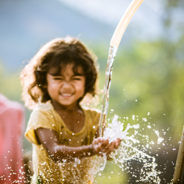 Girl enjoys her family's clean water source in Bac Ai, Phuoc Hoa, Ninh Thuan.