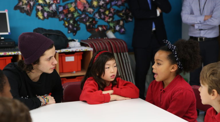 Cel Spellman speaking with children in a London school