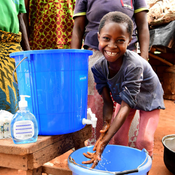 child handwashing smiling