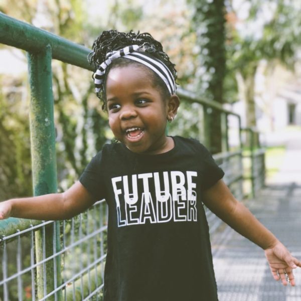 Young girl smiling and wearing a 'future leader' t-shirt'