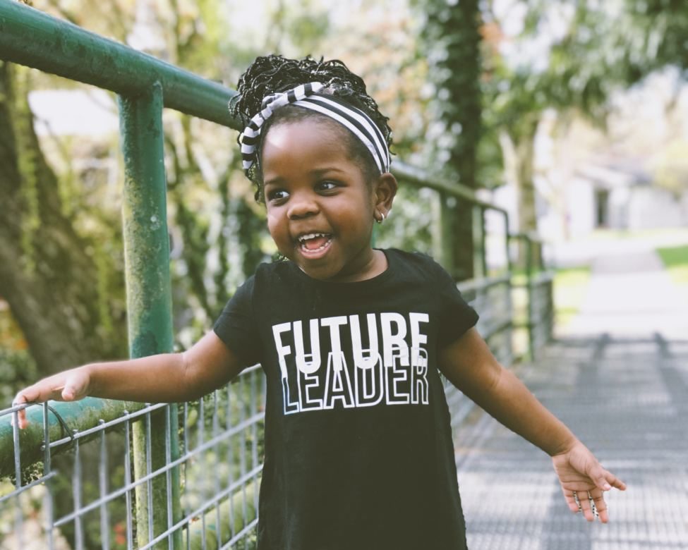 Young girl smiling and wearing a 'future leader' t-shirt'