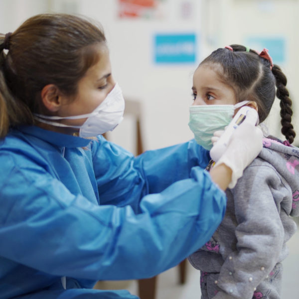 On 3 April 2020, a nurse takes a girl’s temperature at a Primary Health Care Centre in Beirut, Lebanon.