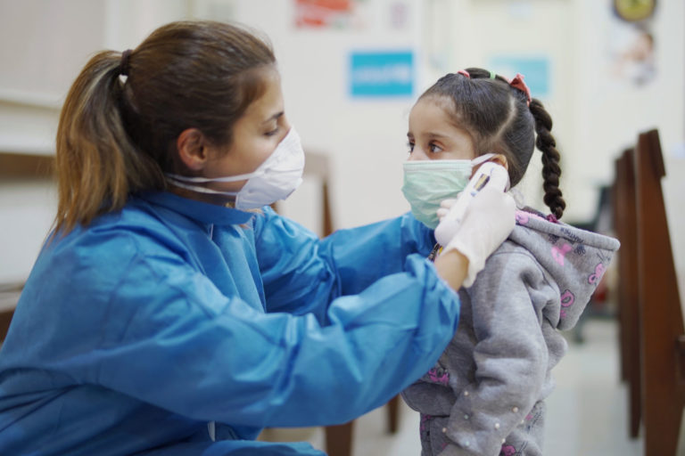 On 3 April 2020, a nurse takes a girl’s temperature at a Primary Health Care Centre in Beirut, Lebanon.