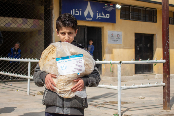 On 2 April 2020, Mohammad, 11, holds a bread bag containing messages raising awareness on issues around the 2019 novel coronavirus, in the al-Zebdieh neighbourhood of Aleppo, Syrian Arab Republic.