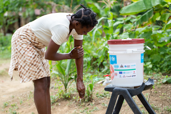 Mariama, an Ebola survivor, hangs heavy duty personal protection gloves on a line to dry.