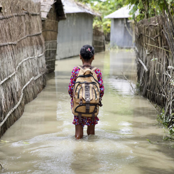 A child wades through water on her way to school in Bangladesh. © UNICEF/Akash