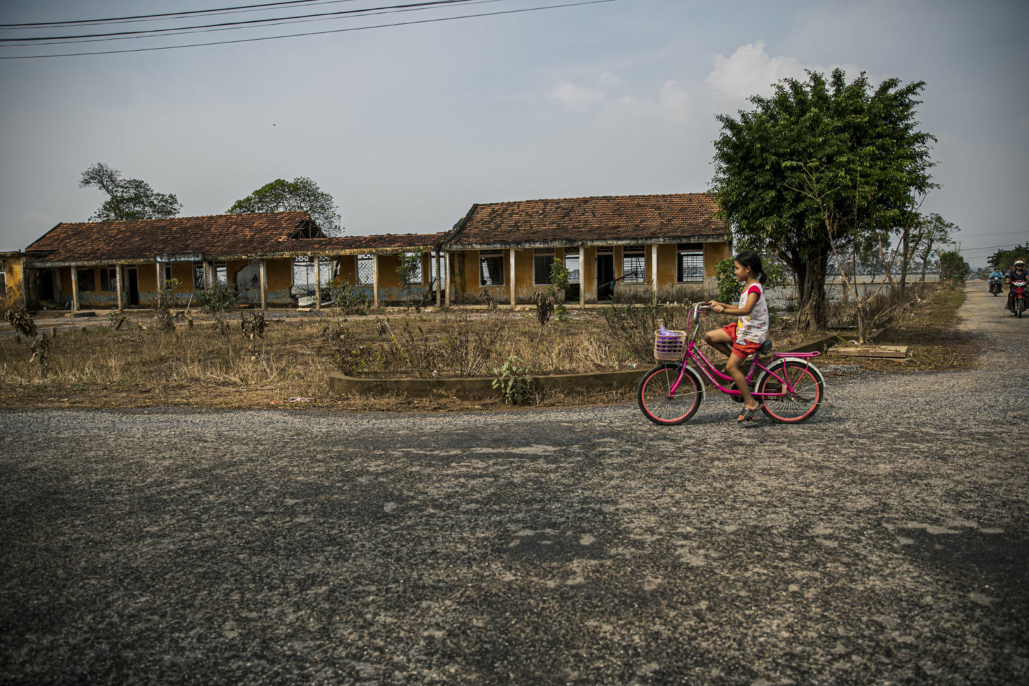 A girl cycles past buildings damaged by strong typhoons and floods in Le Thuy, Quang Binh, central Viet Nam.